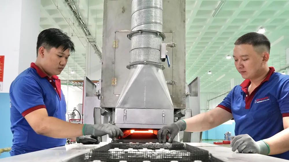 Sản phẩm từ ép bột kim loại của Công ty TNHH Cơ khí Duy Khanh đang được đưa vào dây chuyền gia nhiệt. Ảnh: HOÀNG HÙNG