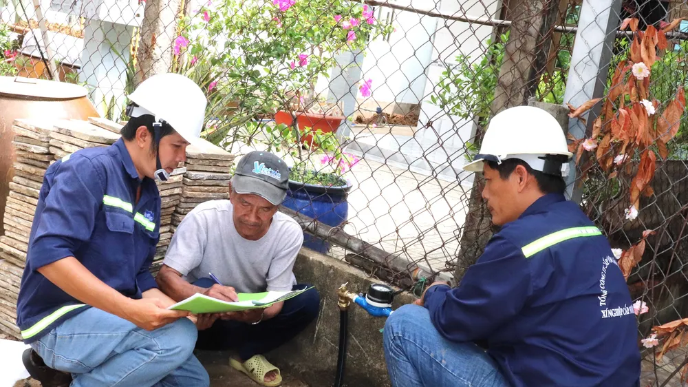 Ông Nguyễn Văn Tới (giữa), ngụ tổ 4, ấp An Hòa, xã Tam Thôn Hiệp (huyện Cần Giờ) ký nhận đồng hồ nước vừa được lắp đặt từ Xí nghiệp Cấp nước Cần Giờ