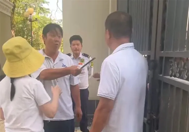 Hình ảnh bà Nguyễn Thị Út Em (người đội mũ màu vàng) cùng một số người đến trước cổng trường vào chiều 26-3
