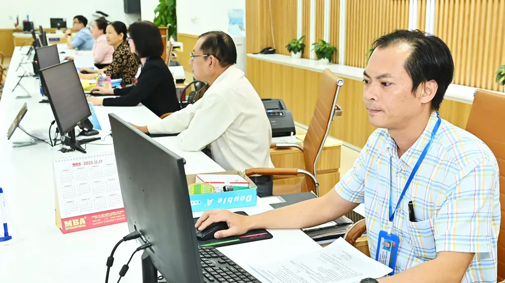 Cán bộ công chức làm việc tại Bộ phận tiếp nhận và trả kết quả của quận 6. Ảnh: VIỆT DŨNG 