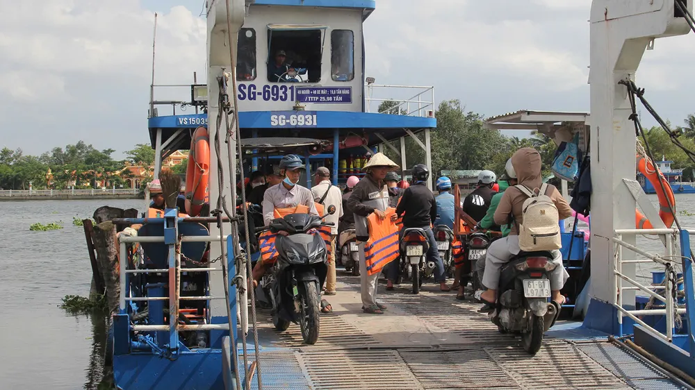 Nhân viên bến đò An Sơn, TPHCM phát áo phao cho khách đi phà. Ảnh: XUÂN TRUNG