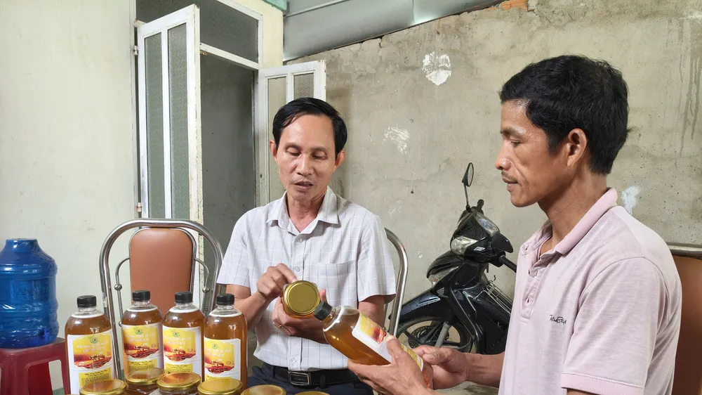 Ông Nguyễn Hồng Châu (bên phải) thuyết minh về sản phẩm mật ong do người dân sản xuất