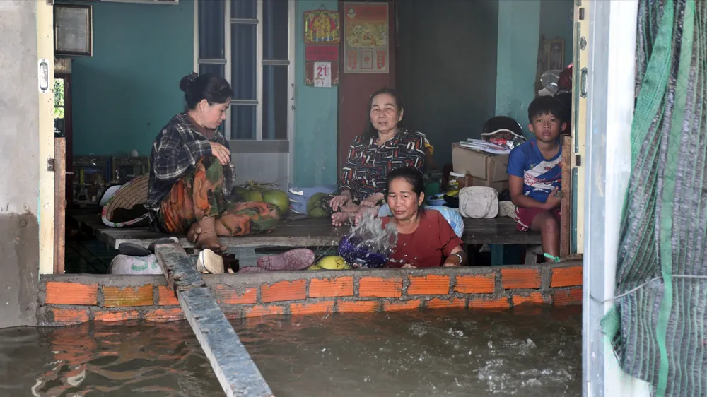 Bà Đỗ Thị Bé Hai, ấp Láng Sen, xã Vĩnh Châu và người thân tát nước ra khỏi nhà