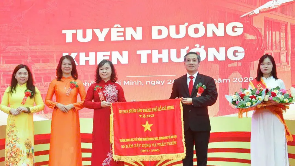 Ông Nguyễn Kế Toại, Phó Giám đốc Sở GD-ĐT TPHCM, trao cờ thi đua của UBND TPHCM tặng Trường THPT Nguyễn Trung Trực