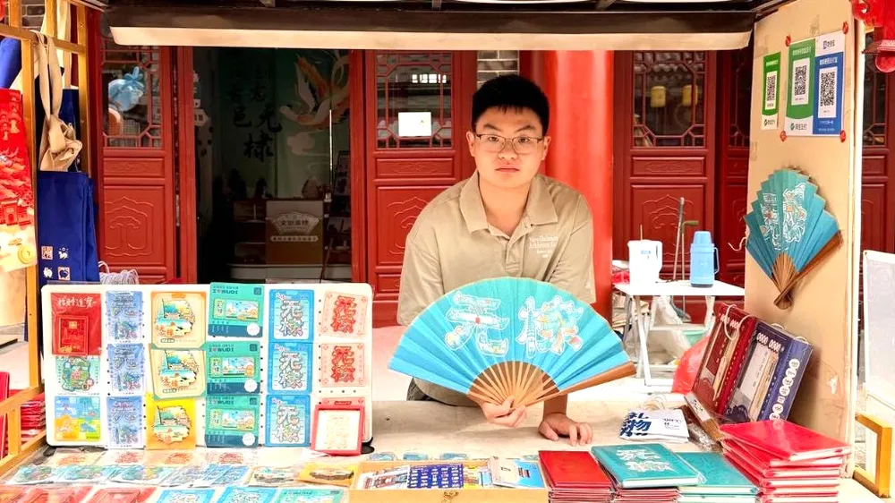 Lý Trạch Di bán các sản phẩm do chính anh thiết kế trước cửa hàng văn hóa và sáng tạo của mình tại huyện Vũ Đế. Ảnh: THX