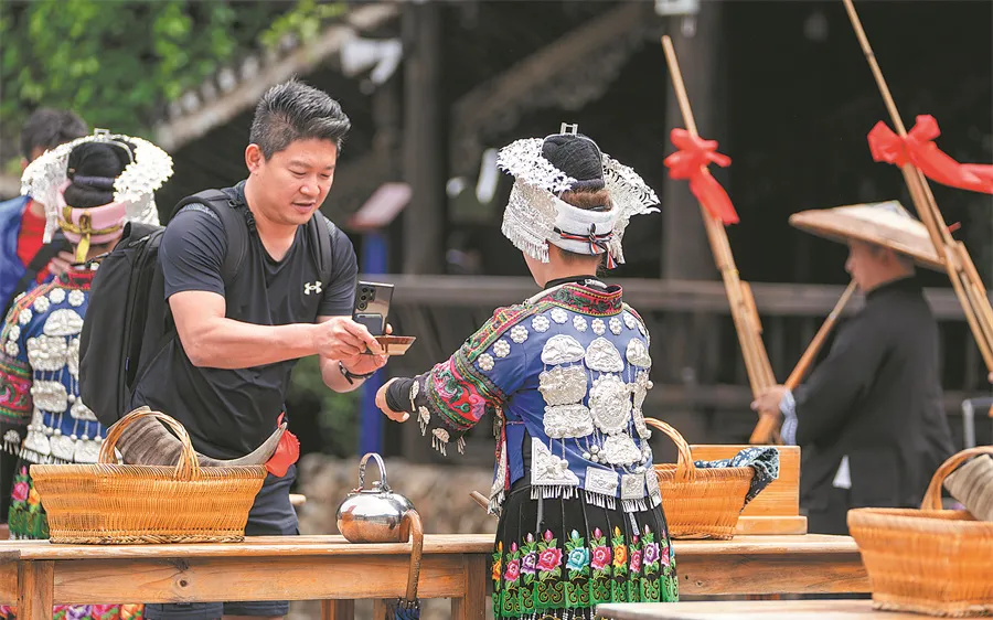 Trải nghiệm văn hóa tại Tây Giang Thiên Hộ Miêu Trại. Ảnh: CHINA DAILY