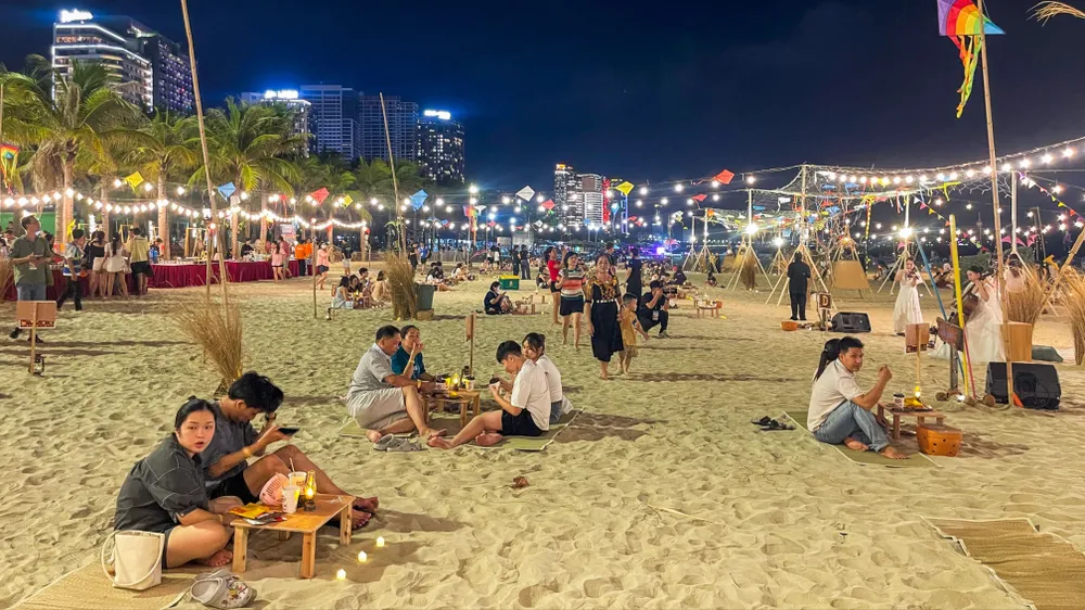 Không gian biển đêm được phủ bởi hàng trăm cụm đèn nghệ thuật, kết hợp bàn tiệc ven biển, ánh nến, đèn dầu và âm nhạc acoustic, tạo nên điểm nhấn mới cho du lịch đêm
