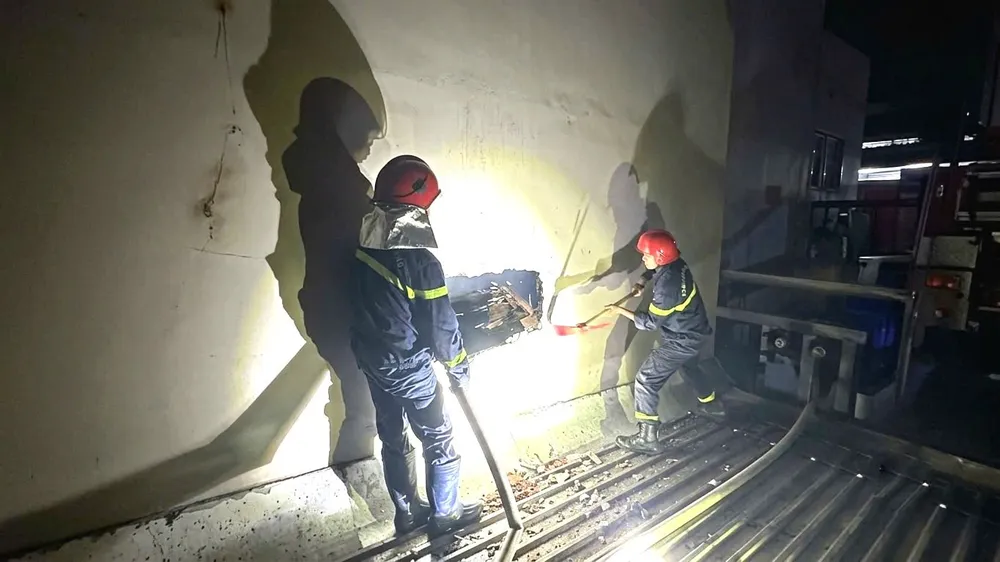 Lực lượng chức năng phá tường để tiếp cận căn nhà bị cháy