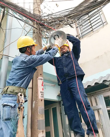 Đoàn viên thanh niên ngành điện thi công lắp mới đèn chiếu sáng tuyến hẻm