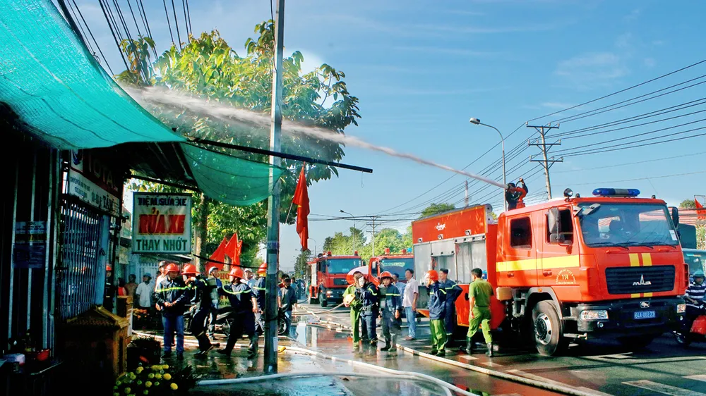  Các lực lượng tham gia chữa cháy. Ảnh: DƯƠNG THỤ