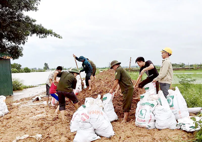 Bộ đội cùng người dân huyện Quốc Oai (Hà Nội) chung sức đắp đê bao ngăn nước lũ sông Tích tràn vào khu dân cư ngày 22-7
