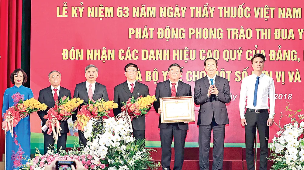 Chủ tịch nước Trần Đại Quang trao Huân chương Lao động hạng nhì cho Bệnh viện Bạch Mai. Ảnh: TTXVN