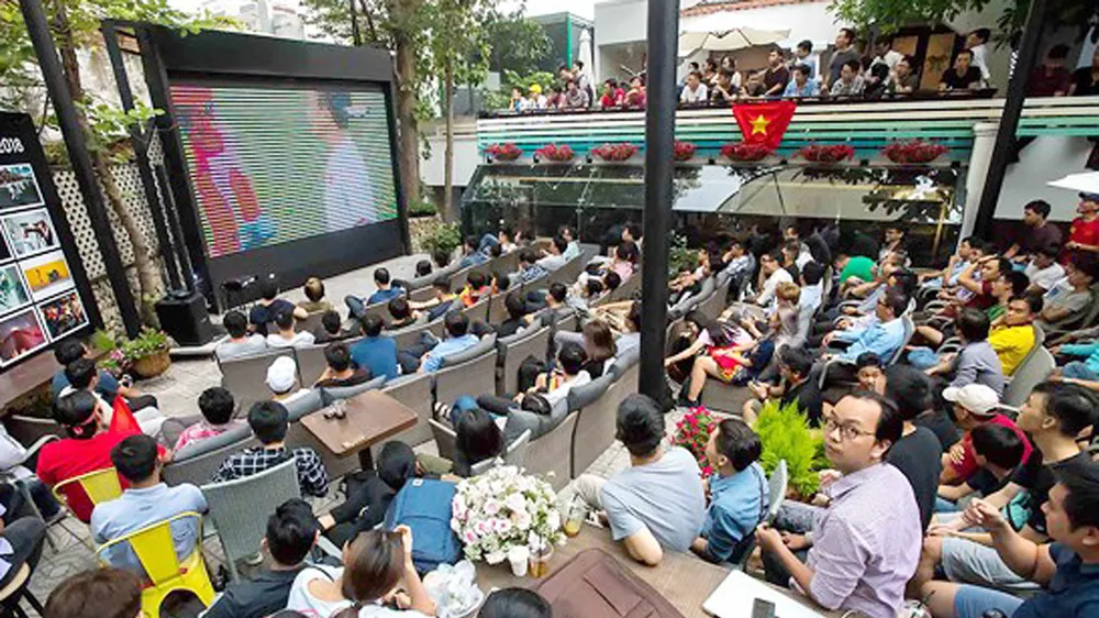 Người hâm mộ xem truyền hình trực tiếp bóng đá ngoài trời. Ảnh: DŨNG PHƯƠNG