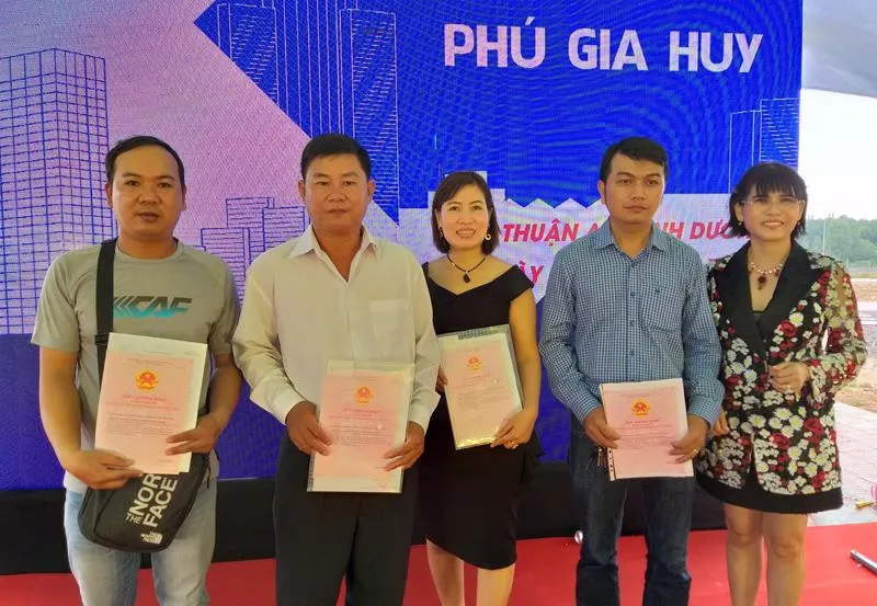 Lãnh đạo công ty trao sổ đỏ cho khách hàng