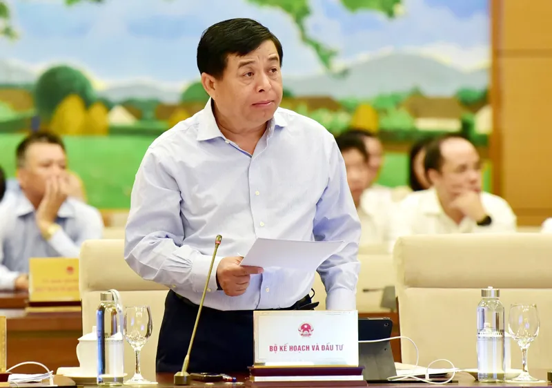Bộ trưởng Bộ KH-ĐT Nguyễn Chí Dũng trình bày báo cáo về kinh tế - xã hội. Ảnh: TTXVN