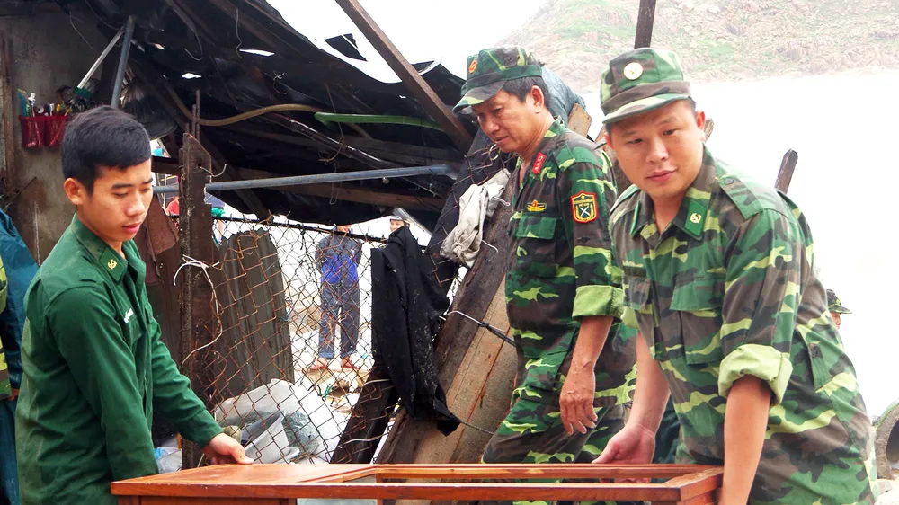 Chiến sĩ bộ đội biên phòng tỉnh Bình Định hỗ trợ người dân khắc phục hậu quả sau bão. Ảnh: XUÂN HUYÊN