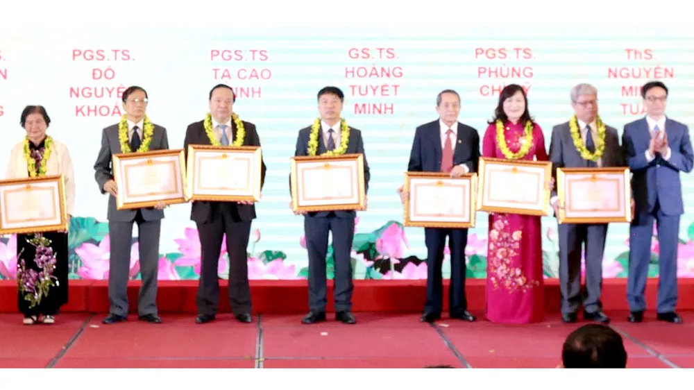 Phó Thủ tướng Vũ Đức Đam trao bằng khen tôn vinh 7 trí thức khoa học - công nghệ tiêu biểu năm 2019. Ảnh: TTXVN