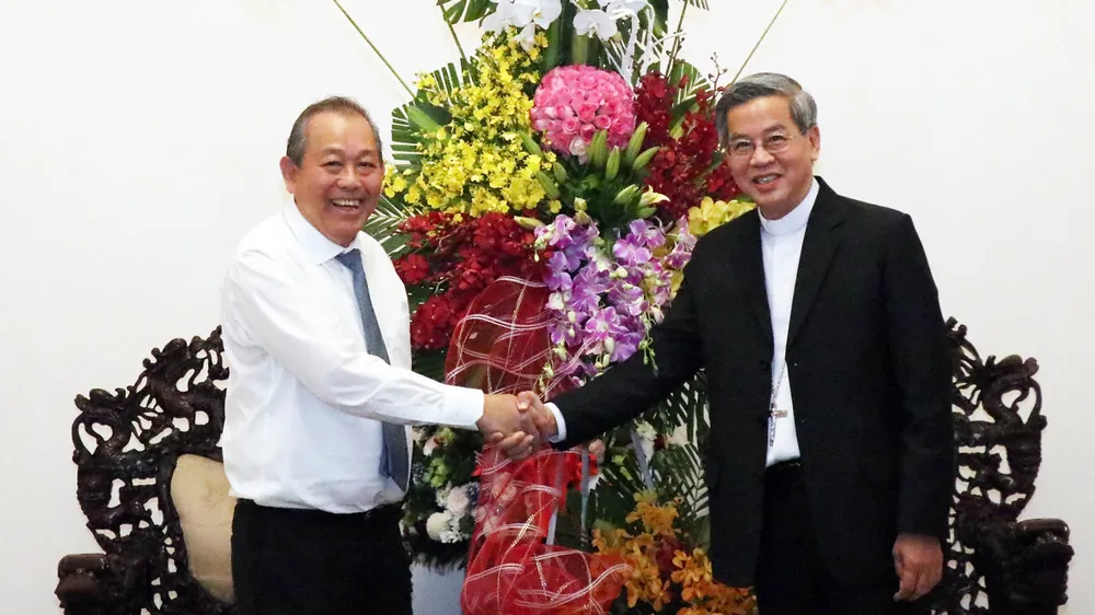Phó Thủ tướng Thường trực Trương Hòa Bình trao lẵng hoa của Tổng Bí thư, Chủ tịch nước Nguyễn Phú Trọng chúc mừng Tổng Giám mục Giuse Nguyễn Năng. Ảnh: TTXVN