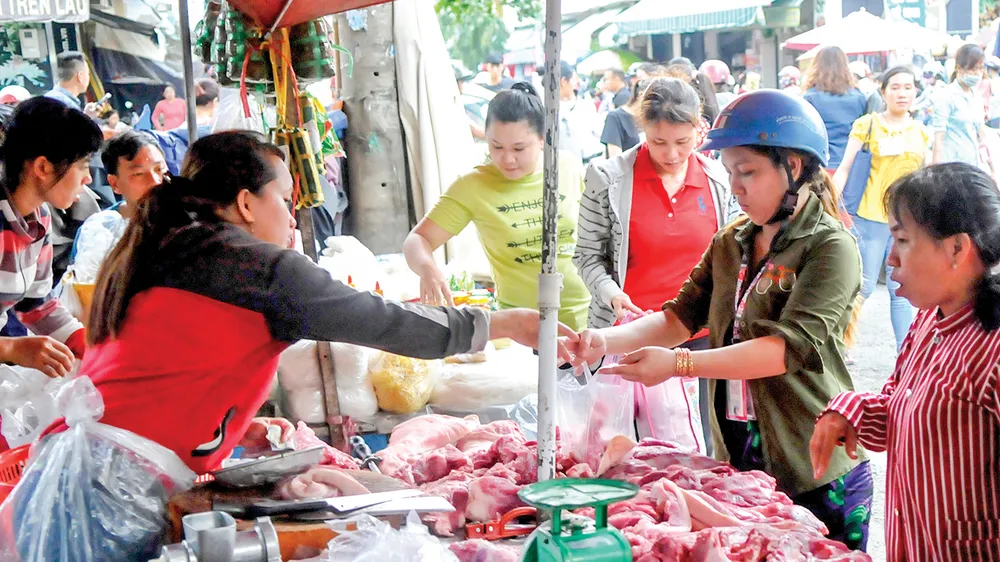 Người tiêu dùng chọn mua thịt heo tại một chợ ở TPHCM. Ảnh: ĐỨC THIỆN