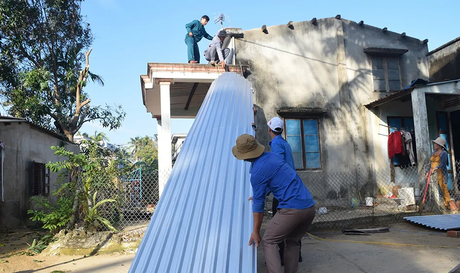 Các bạn trẻ hỗ trợ người dân lợp lại nhà sau bão số 9