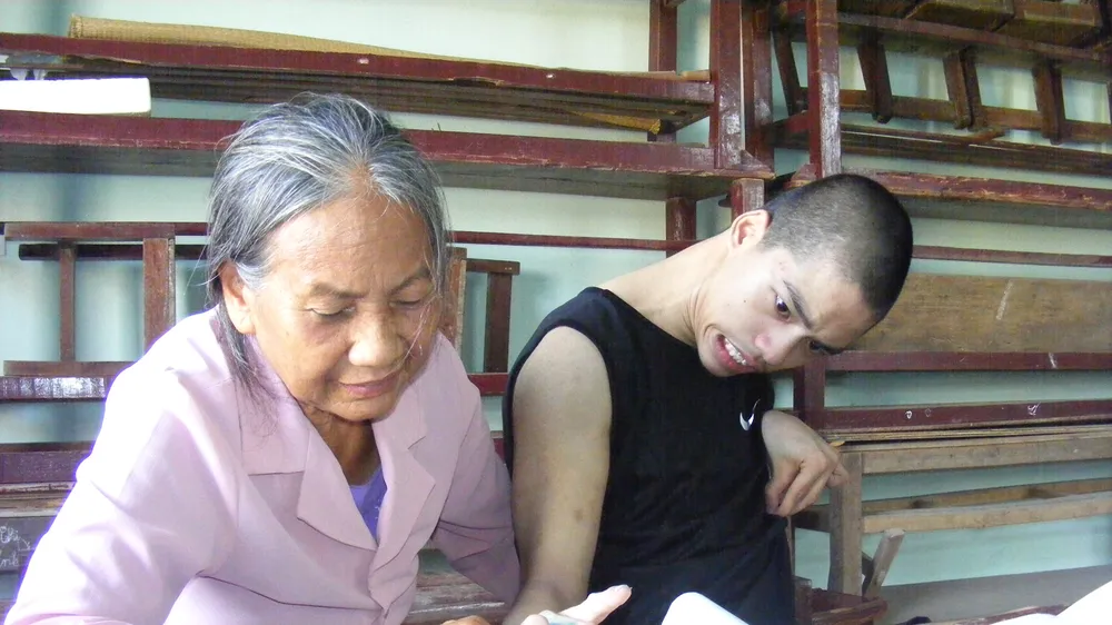 Bà giáo Nguyễn Thị Thông đang dạy cho cháu Nguyễn Văn Nguyên 