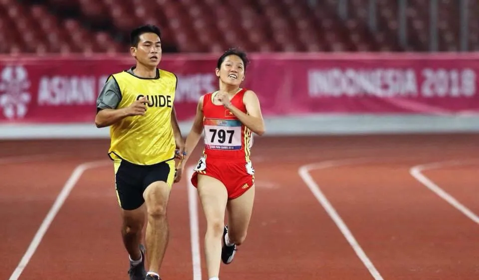 HLV Nguyễn Văn Phương (trái) dẫn VĐV điền kinh khuyết tật Việt Nam thi đấu ở Asian Paragames 2018. Ảnh: P.NGUYỄN