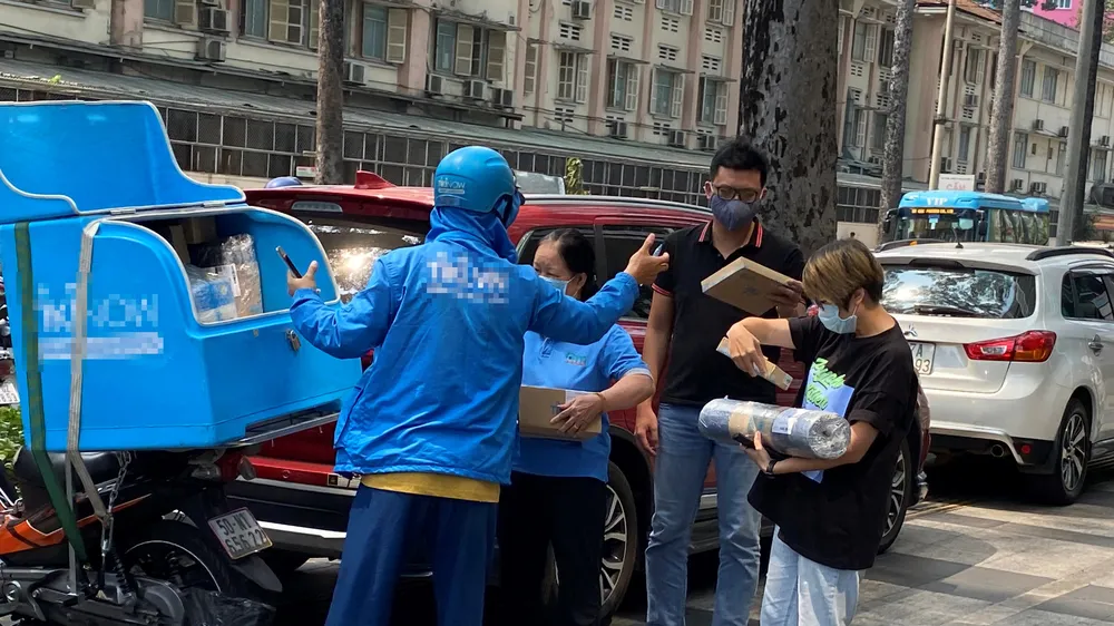 Khách nhận hàng mua trên mạng. Ảnh: CAO THĂNG