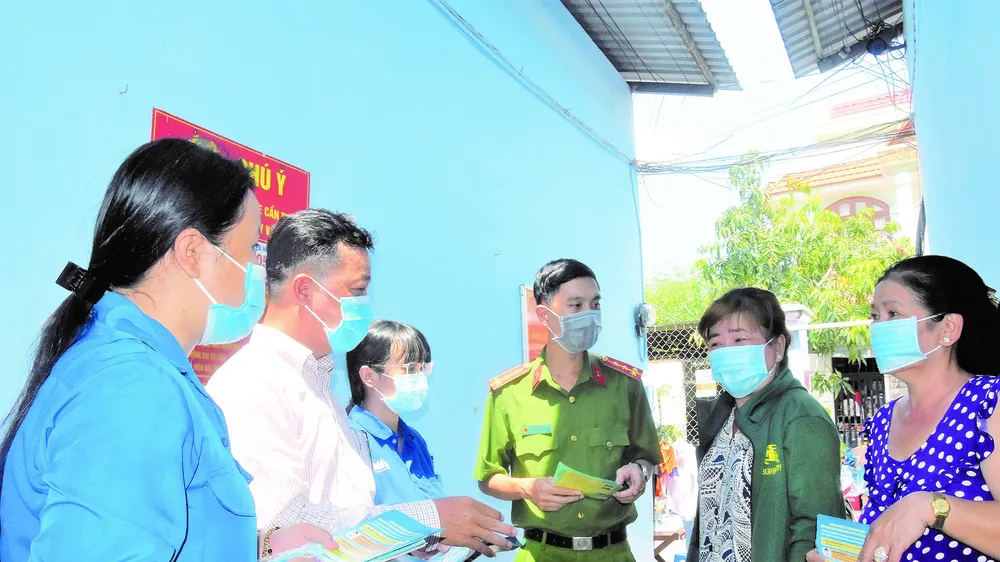 Ông Lê Hoàng Long (thứ hai từ trái qua) cùng các tổ viên tuyên truyền về công tác phòng chống dịch cho người dân ở dãy nhà trọ Nghinh Phong tại ấp 5, xã Phú Xuân, huyện Nhà Bè, TPHCM