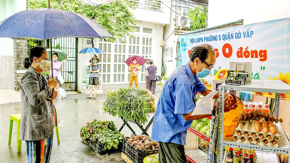 Người dân khu cách ly phường 5, quận Gò Vấp, TPHCM lần lượt vào kệ hàng 0 đồng lấy hàng hóa cần thiết trong ngày. Ảnh: HOÀNG HÙNG