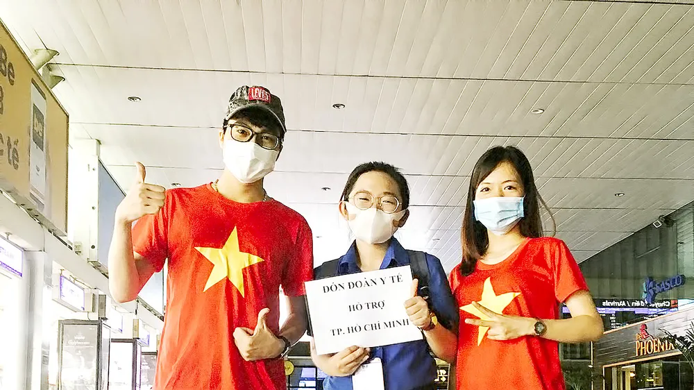Minh Thy (giữa) và các bạn tình nguyện viên đón đoàn y bác sĩ từ các tỉnh thành chi viện cho TPHCM