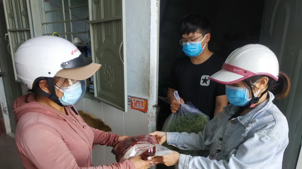 Công nhân ở khu trọ Tổ 5A nhận quà hỗ trợ từ đại diện UBND phường Tăng Nhơn Phú B (TP Thủ Đức). Ảnh: MINH NGHĨA