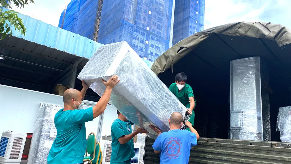 Nhân viên y tế Trung tâm Hồi sức Covid-19 do BV Bạch Mai quản lý đang vận chuyển đồ đạc trở về Hà Nội