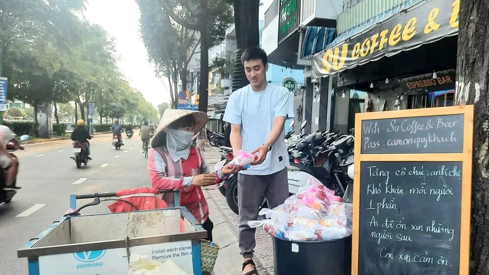 Một tuần 3 lần, quán kê chiếc bàn nhỏ phía trước, bày những túi nhỏ, mỗi túi có chai nước suối ướp lạnh, ổ bánh mì thịt