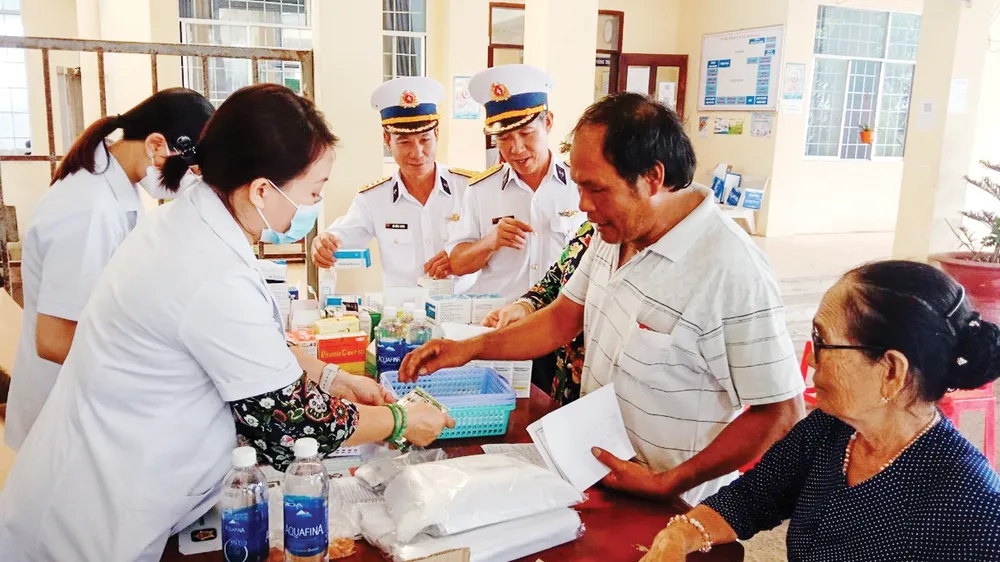 Các y, bác sĩ Vùng 2 Hải quân phối hợp với Bệnh viện Lê Văn Thịnh thăm khám, tư vấn sức khỏe và cấp thuốc miễn phí cho ngư dân xã Bình Châu