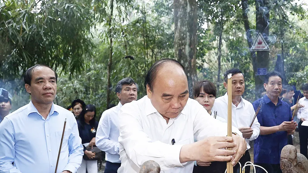 Chủ tịch nước Nguyễn Xuân Phúc cùng đoàn công tác dâng hương tưởng nhớ Chủ tịch Hồ Chí Minh tại lán Nà Nưa trong Khu di tích lịch sử quốc gia đặc biệt Tân Trào. Ảnh: TTXVN