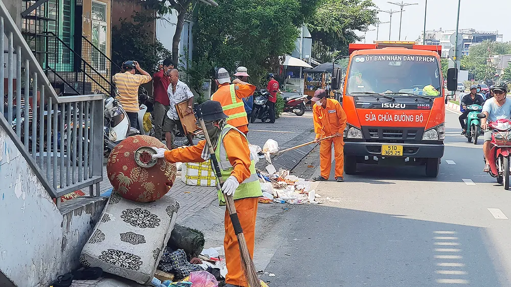 Đơn vị thu gom rác của thành phố thu dọn các bãi rác hoang trên đường Phạm Văn Đồng