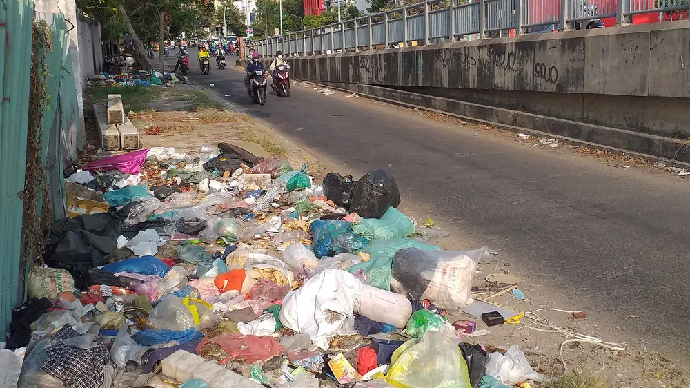 Vô số bịch rác, xà bần lớn nhỏ nằm ngổn ngang trên đường bên hông cầu Him Lam