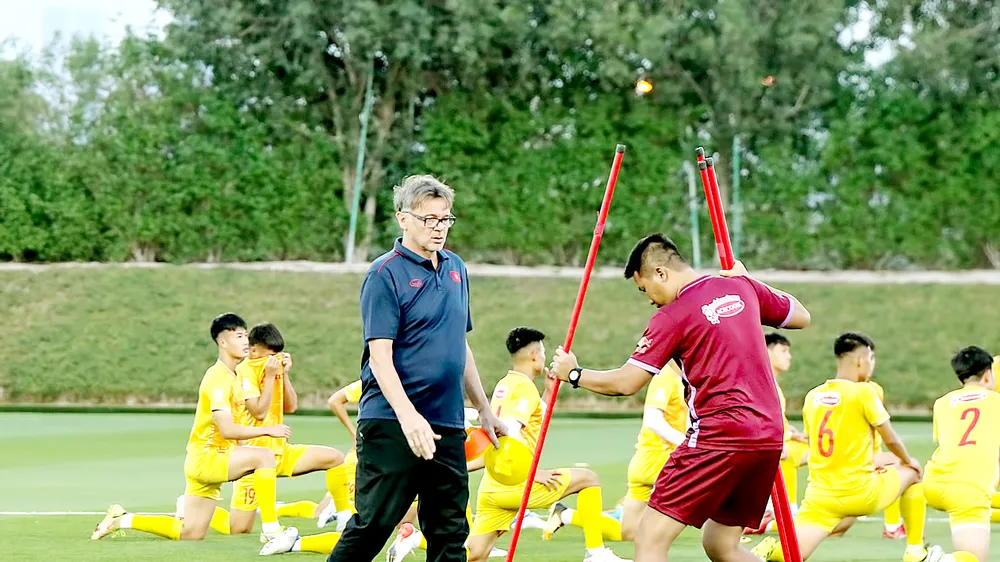 HLV Troussier cùng các học trò trên sân tập chuẩn bị cho trận đấu với U23 Kyrgyzstan. Ảnh: THANH QUỐC