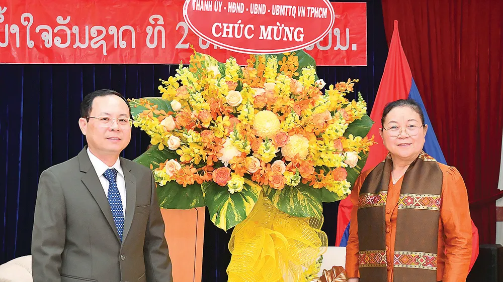 Phó Bí thư Thành ủy TPHCM Nguyễn Văn Hiếu tặng hoa chúc mừng Tổng Lãnh sự Lào Phimpha Keomixay nhân dịp Tết cổ truyền Lào. Ảnh: VIỆT DŨNG 