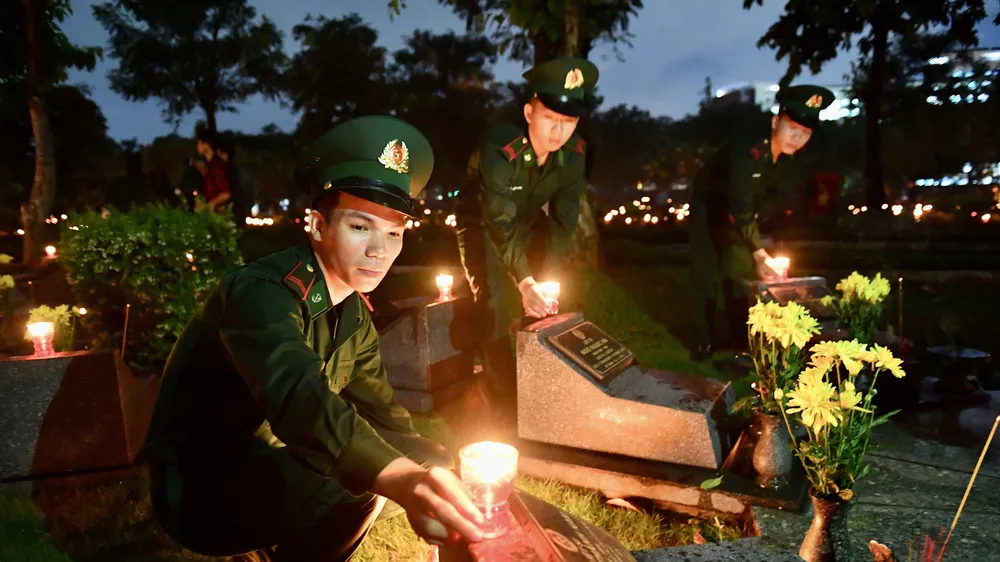 Đoàn viên, thanh niên TPHCM thắp nến tri ân các anh hùng liệt sĩ tại Nghĩa trang Liệt sĩ TPHCM. Ảnh: VIỆT DŨNG 