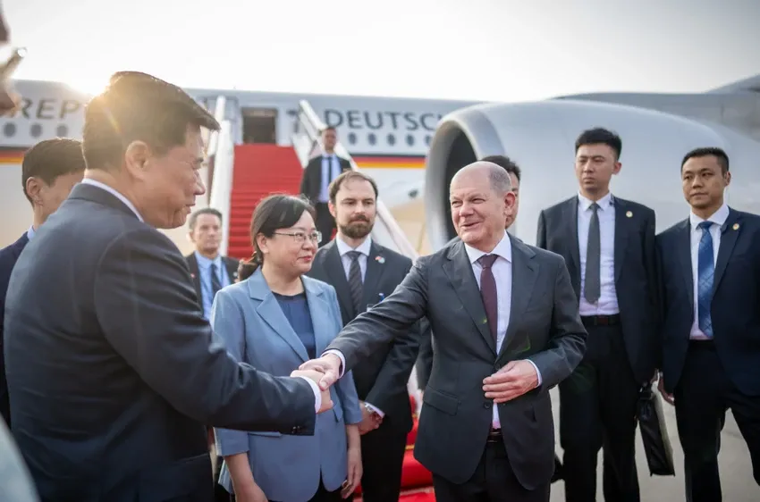 Thủ tướng Đức Olaf Scholz (phải) đang bắt tay với một quan chức Trung Quốc khi đến TP Trùng Khánh (Trung Quốc) hôm 14-4. Ảnh: BLOOMBERG
