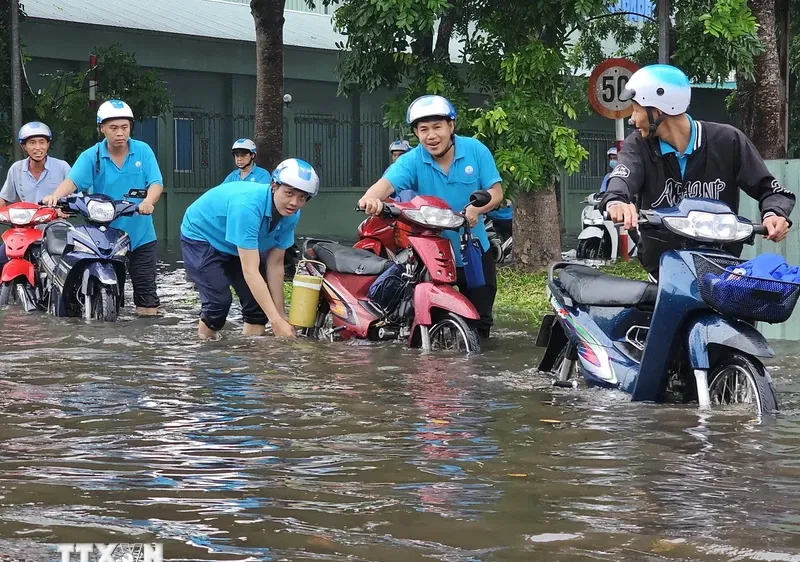 Nhiều công nhân lội nước đi làm tại Khu công nghiệp Giao Long. Ảnh: TTXVN