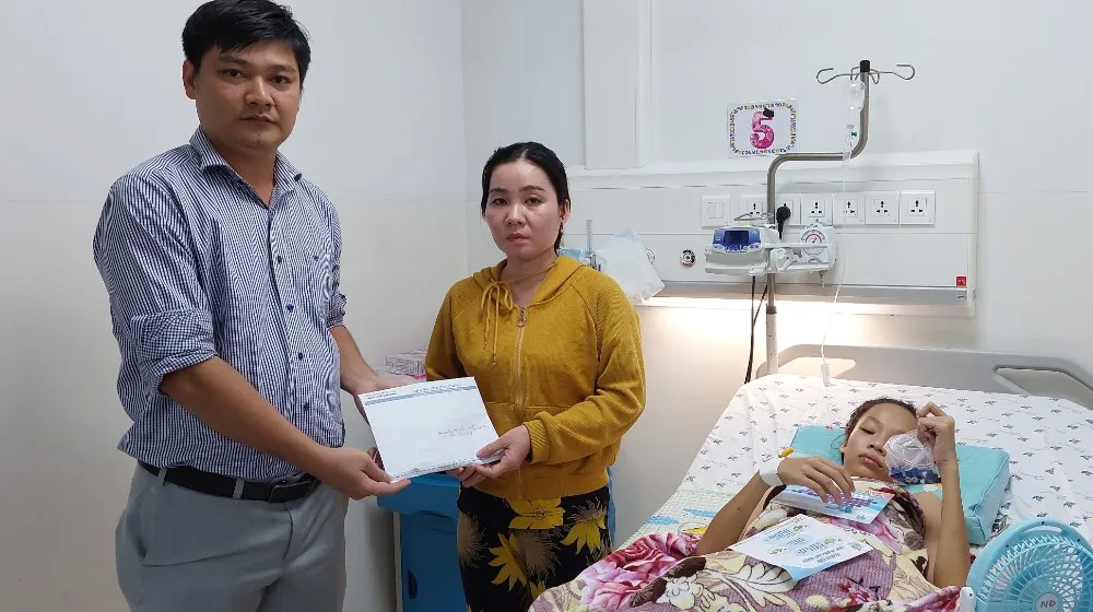 Đại diện Báo SGGP trao số tiền của bạn đọc hỗ trợ cho gia đình em Nguyễn Trần Anh Thư