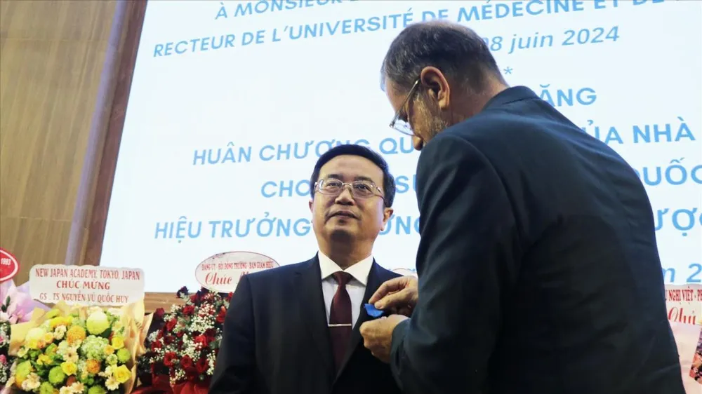 Ông Olivier Brochet, Đại sứ Cộng hòa Pháp tại Việt Nam, thay mặt Tổng thống Cộng hòa Pháp trao Huân chương Công trạng Quốc gia, tước hiệu Hiệp sĩ cho GS-TS Nguyễn Vũ Quốc Huy. Ảnh: TTXVN