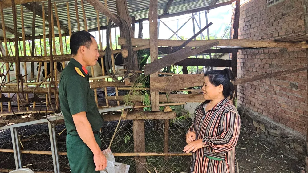 Đại úy Nguyễn Trung Hải thăm và hướng dẫn bà Đàm Thị Bình chăm sóc phát triển đàn dê