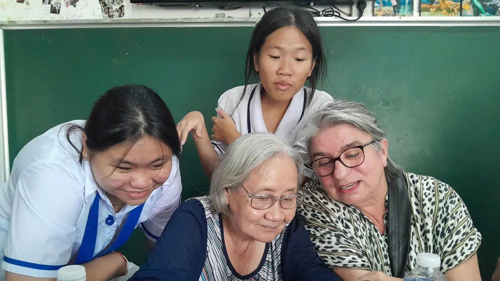 Bà Đoàn Lê Phong (giữa), Phó ban Thường trực Ban Liên lạc cựu tù chính trị và tù binh TPHCM, Phó Chủ tịch Hội Phụ nữ từ thiện TPHCM và các em ở mái ấm do hội phụ trách