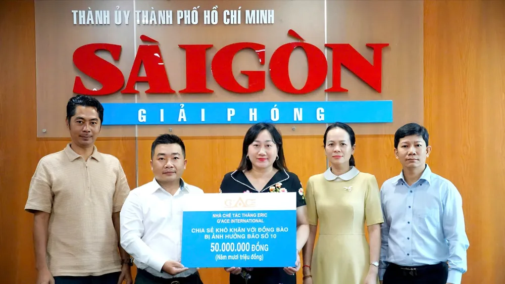 Báo Sài Gòn Giải Phóng tiếp nhận bảng trao 50 triệu đồng chia sẻ khó khăn với đồng bào bị ảnh hưởng bão số 10 từ Nhà chế tác Thắng Eric. Ảnh: VIỆT NGA