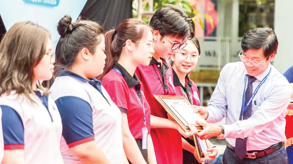 PGS-TS Nguyễn Xuân Hoàn, Hiệu trưởng Trường ĐH Công thương TPHCM trao học bổng cho sinh viên vượt khó học giỏi. Ảnh: THANH HÙNG