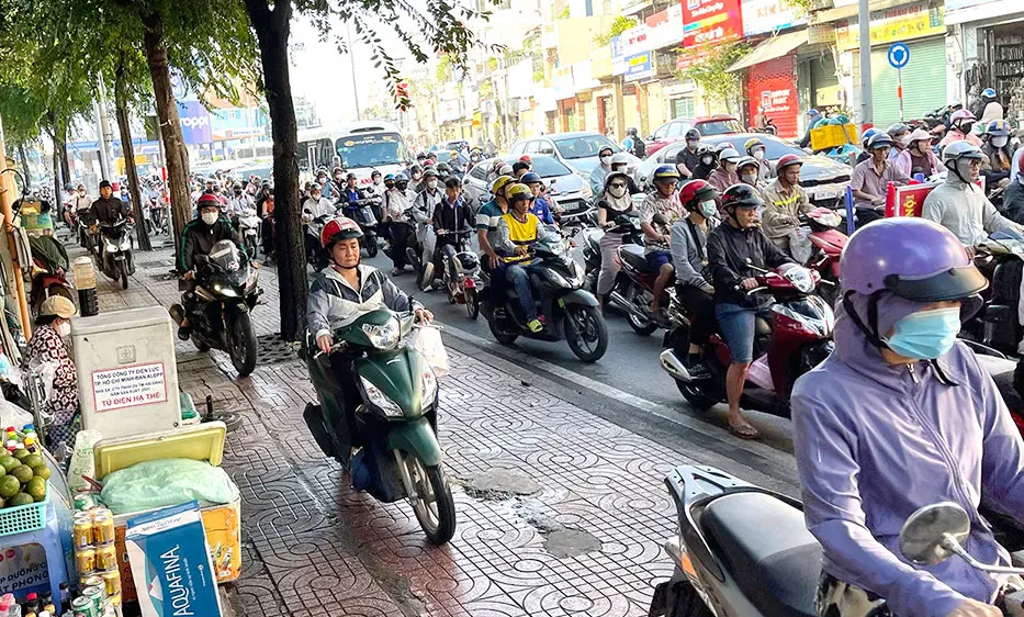 Nhiều người chạy xe máy lên vỉa hè đường Lý Thường Kiệt, phường Tân Sơn Nhất, TPHCM. Ảnh: HOÀNG HÙNG