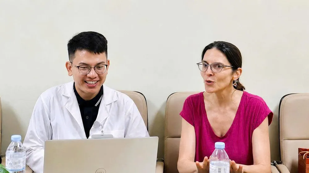 Bác sĩ Lê Hồng Thái (trái) trao đổi chuyên môn với TS-BS Delphine Natali (Pháp) tại Bệnh viện K (Ảnh: NVCC)